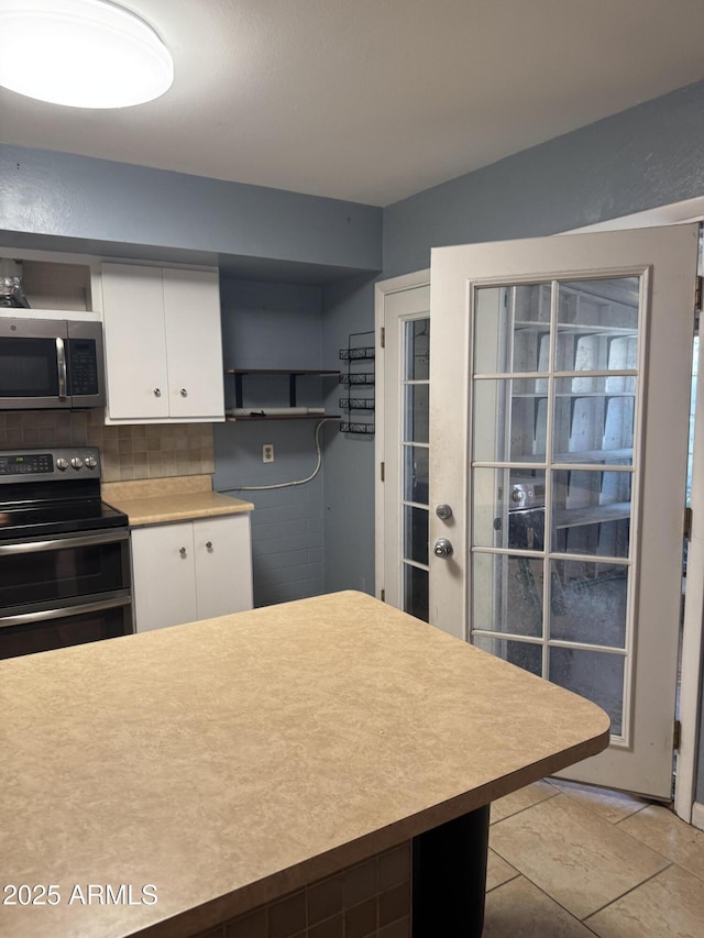 5363 N Black Canyon Highway, Phoenix, AZ 85015 - kitchen with white cabinets, open shelves, light countertops, appliances with stainless steel finishes, and backsplash