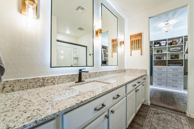 bathroom featuring hardwood / wood-style flooring, walk in shower, and vanity