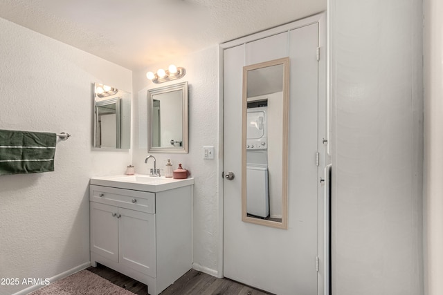 461 W Holmes Ave Unit 350, Mesa, AZ 85210 - bathroom with stacked washer / dryer, vanity, wood finished floors, and a textured wall