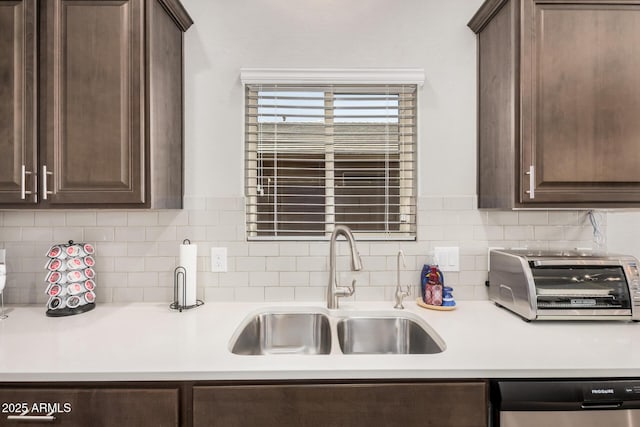 kitchen featuring dishwasher, a sink, and dark brown cabinetry
