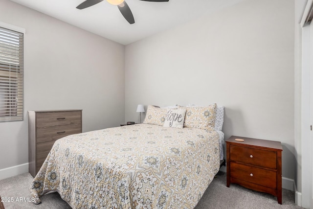 carpeted bedroom featuring baseboards and a ceiling fan