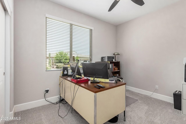 office featuring ceiling fan, baseboards, and light carpet