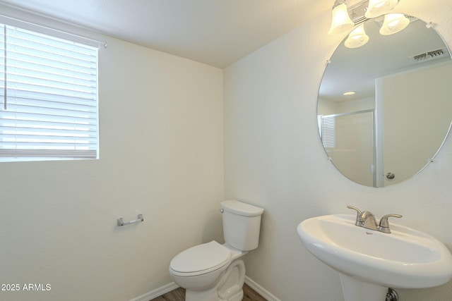 full bathroom featuring an enclosed shower, a sink, toilet, and baseboards