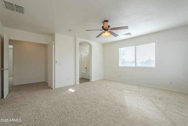 unfurnished bedroom with arched walkways, baseboards, visible vents, and carpet flooring