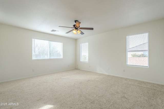 unfurnished room with carpet floors, ceiling fan, visible vents, and baseboards