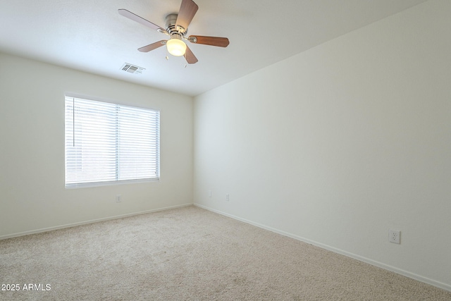 carpeted empty room with visible vents, ceiling fan, and baseboards