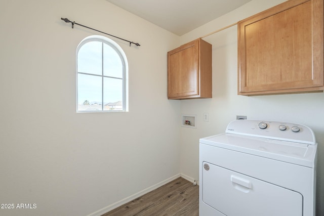 washroom with cabinet space, wood finished floors, washer / dryer, and baseboards