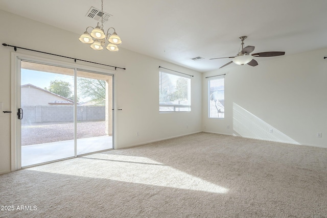 carpeted empty room with ceiling fan with notable chandelier, visible vents, and baseboards