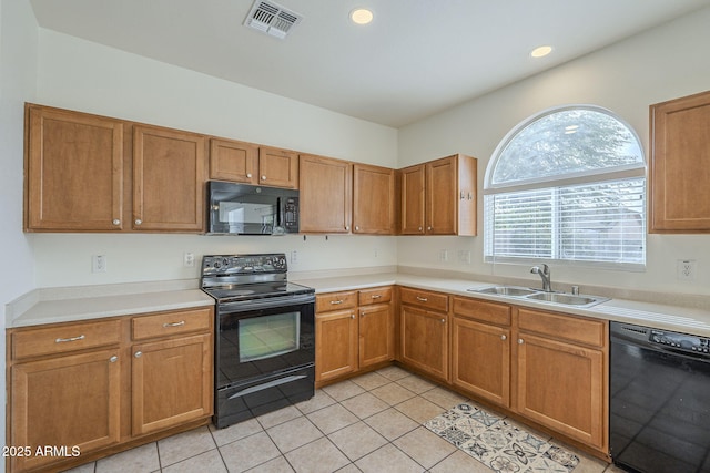 kitchen with visible vents, brown cabinets, light countertops, black appliances, and a sink