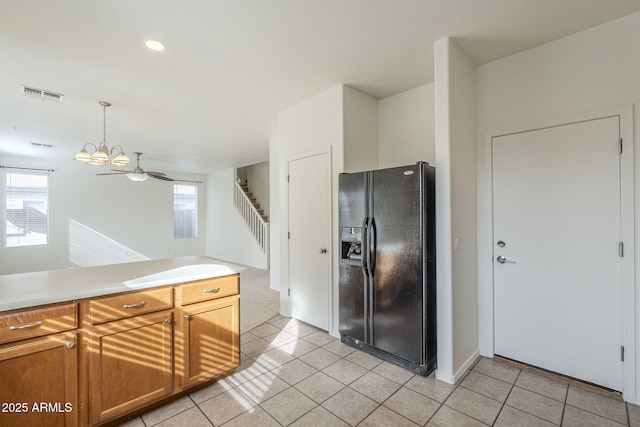 kitchen featuring light countertops, visible vents, black fridge with ice dispenser, and light tile patterned flooring