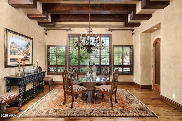 dining space featuring a chandelier, wood finished floors, a healthy amount of sunlight, and beam ceiling