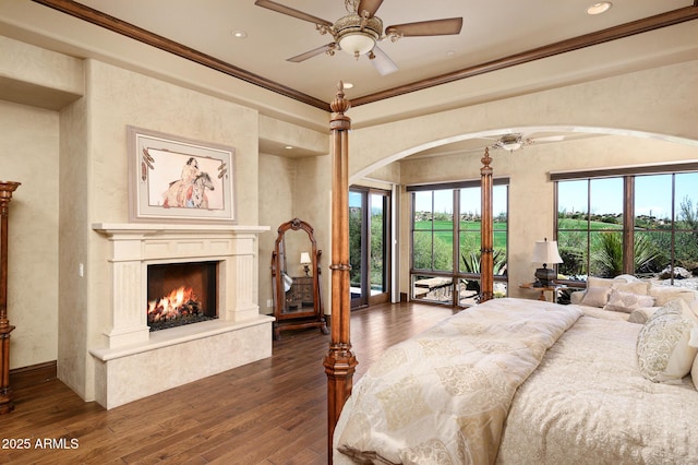 bedroom with access to outside, ornamental molding, arched walkways, and dark wood-style floors
