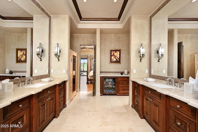 ensuite bathroom featuring beverage cooler, two vanities, and a sink