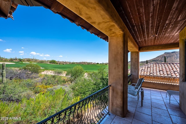 balcony with view of golf course and a mountain view