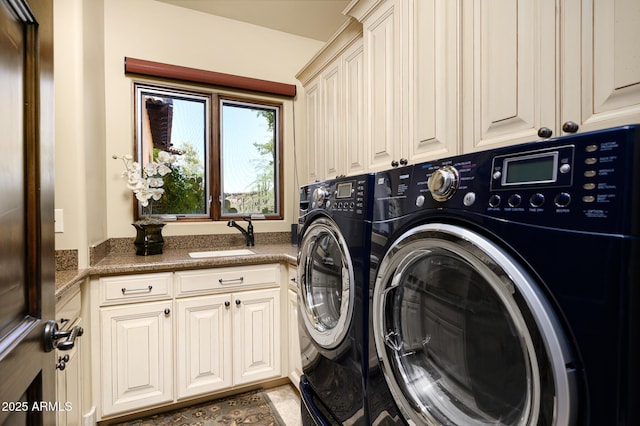 clothes washing area featuring cabinet space, washer and clothes dryer, and a sink