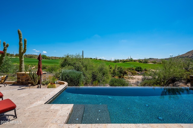 pool with view of golf course and a patio