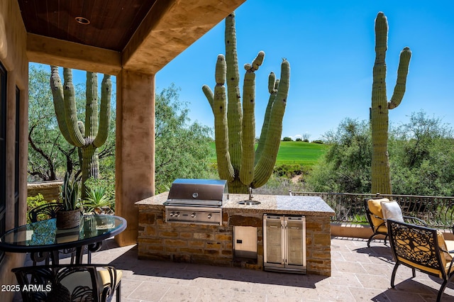 view of patio / terrace with a grill, exterior kitchen, and a sink