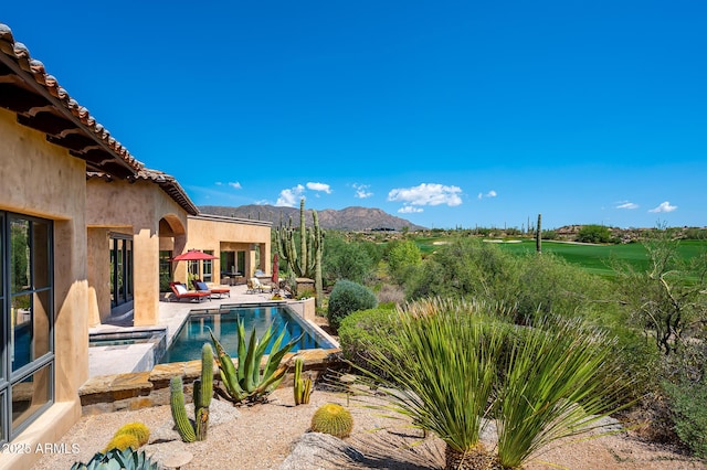 outdoor pool with a patio and a mountain view