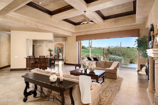 living room with beam ceiling, ceiling fan, arched walkways, coffered ceiling, and baseboards