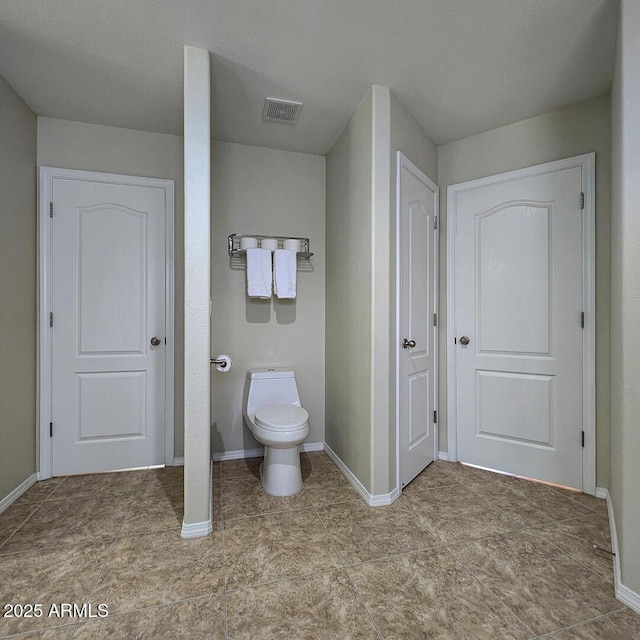 bathroom featuring baseboards and toilet
