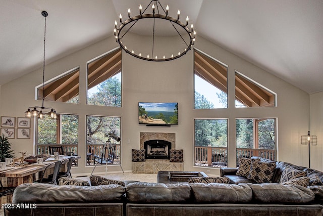 living area featuring high vaulted ceiling, a chandelier, and a fireplace