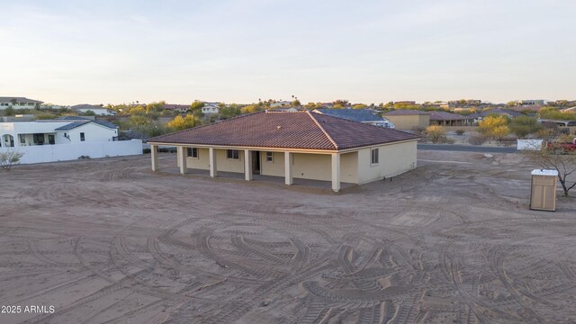 115 Ironwood Pl, Wickenburg, AZ 85390 - exterior space featuring a residential view, a tile roof, a porch, fence, and stucco siding