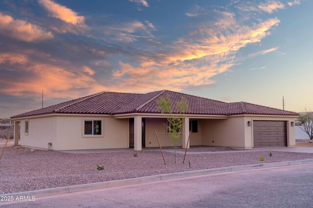 115 Ironwood Pl, Wickenburg, AZ 85390 - mediterranean / spanish-style home featuring a garage, a tile roof, stucco siding, and driveway