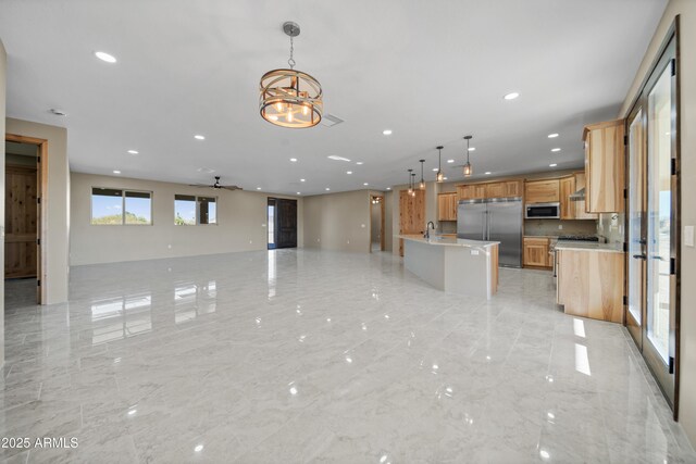 115 Ironwood Pl, Wickenburg, AZ 85390 - kitchen with stainless steel appliances, open floor plan, recessed lighting, marble finish floor, and decorative light fixtures