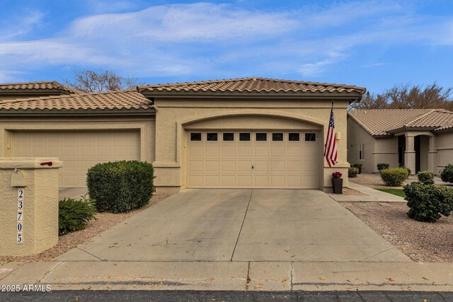 23705 S Pleasant Way, Sun Lakes, AZ 85248 - mediterranean / spanish home featuring an attached garage, concrete driveway, a tile roof, and stucco siding