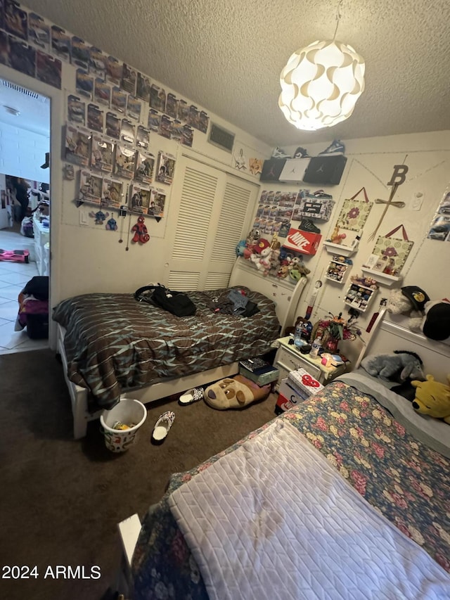 carpeted bedroom featuring a closet and a textured ceiling