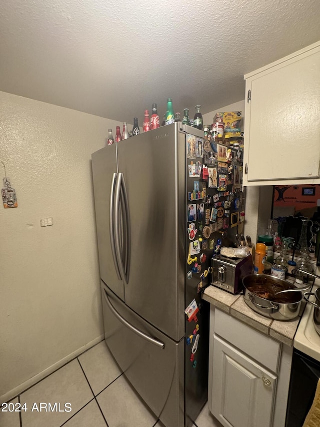 laundry area with a textured ceiling and light tile patterned floors