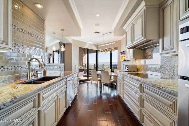 kitchen with cream cabinets, crown molding, black electric cooktop, and a sink