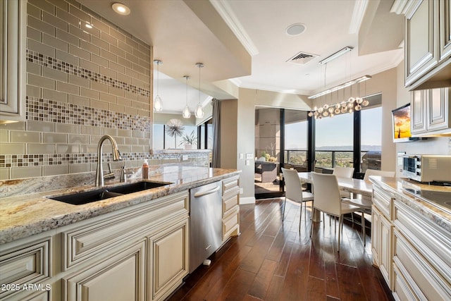 kitchen featuring visible vents, crown molding, cream cabinets, stainless steel dishwasher, and a sink