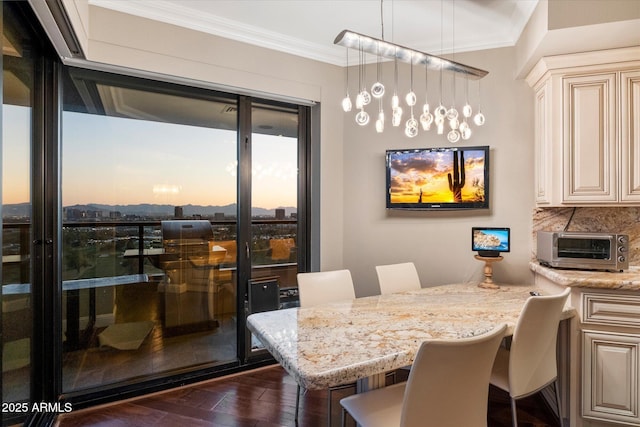 dining space featuring dark wood finished floors, crown molding, and a toaster