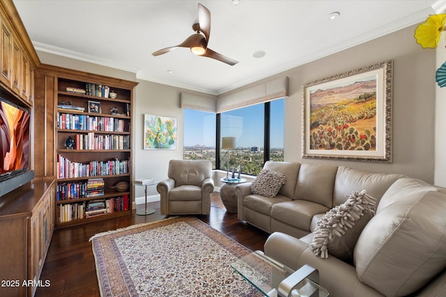 living room with dark wood finished floors, baseboards, a ceiling fan, and ornamental molding