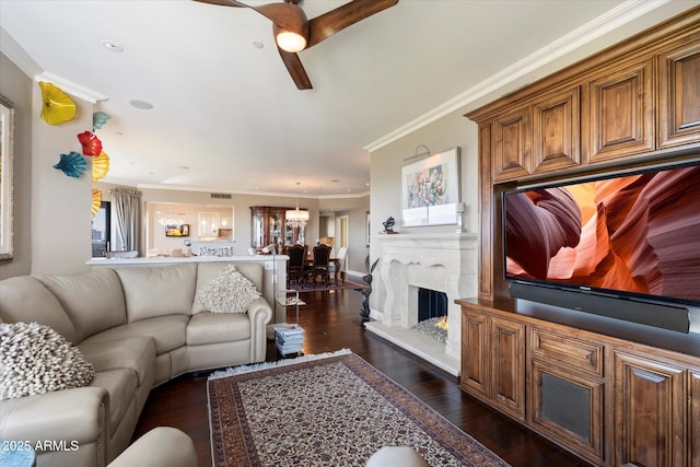 living area with dark wood-type flooring, ornamental molding, and ceiling fan with notable chandelier