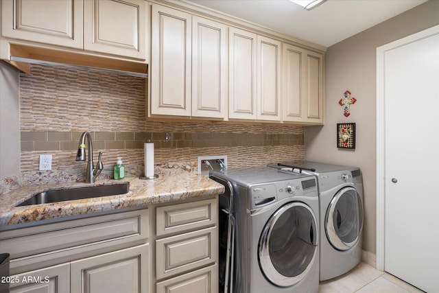 laundry room with washer and clothes dryer, light tile patterned floors, cabinet space, and a sink