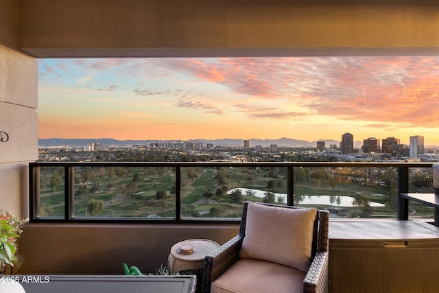 balcony at dusk featuring a city view