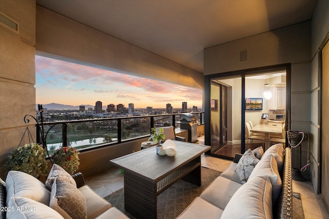 balcony with a view of city, visible vents, and an outdoor hangout area