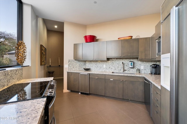 kitchen featuring electric range, backsplash, paneled built in refrigerator, and a sink