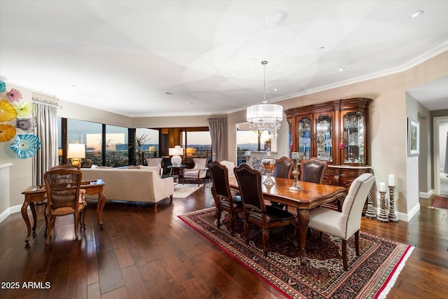 dining space featuring a notable chandelier, dark wood-style floors, baseboards, and ornamental molding