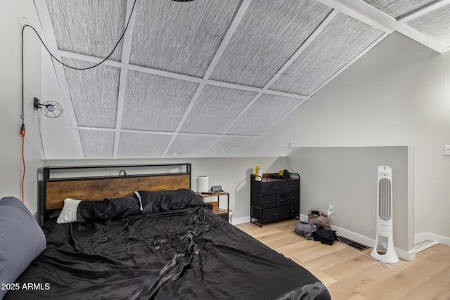 bedroom with lofted ceiling, wood finished floors, and baseboards