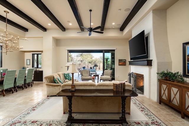 living room featuring beam ceiling and ceiling fan with notable chandelier