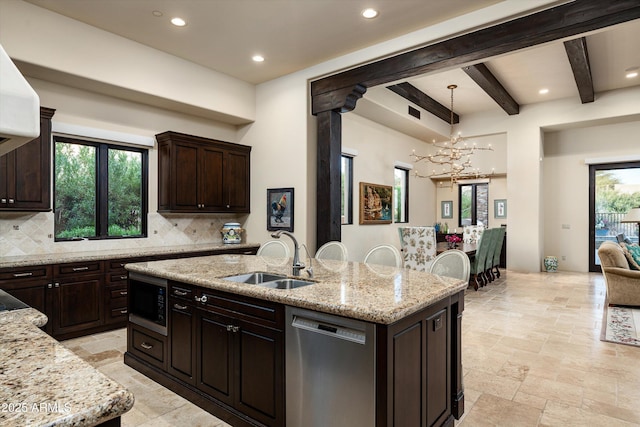 kitchen featuring tasteful backsplash, black microwave, stainless steel dishwasher, an island with sink, and beam ceiling