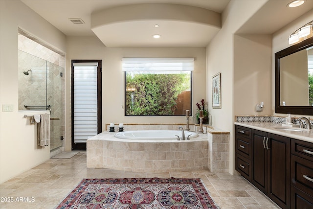 bathroom with vanity and shower with separate bathtub