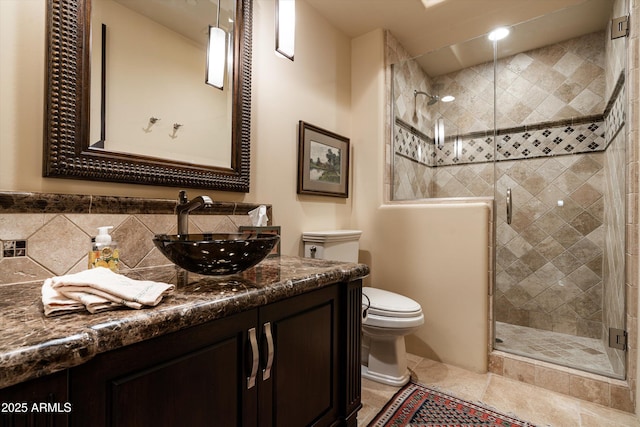 bathroom featuring a shower with door, vanity, and toilet