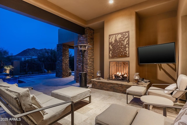 view of patio with a fenced in pool, a mountain view, and an outdoor stone fireplace