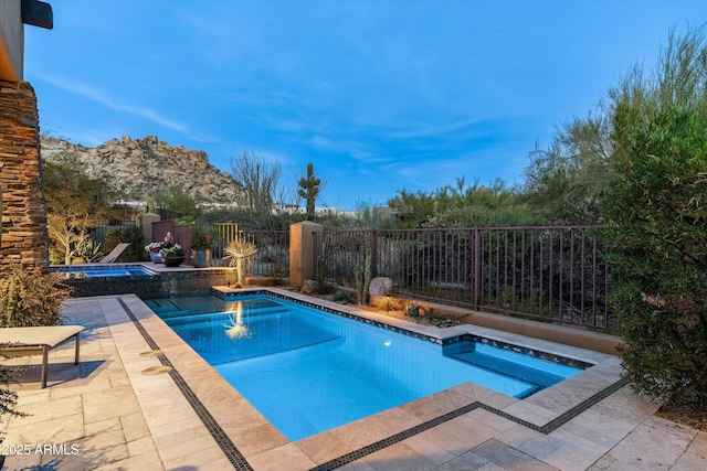 view of pool with a mountain view, a patio, and an in ground hot tub