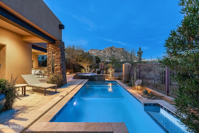 view of pool featuring a mountain view, a patio, and an in ground hot tub