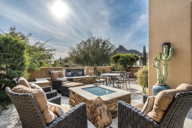 view of patio with an outdoor living space with a fire pit